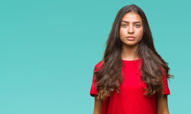 Genç güzel Arap kadın yüzünde ciddi bir ifade ile izole arka plan yüzünden. Basit ve doğal kameraya bakıyor.