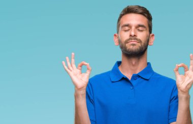 Yakışıklı delikanlı izole arka plan üzerinde dinlenmek ve gülümseyen gözlerle parmak ile meditasyon jest yapıyor kapalı. Yoga kavramı.