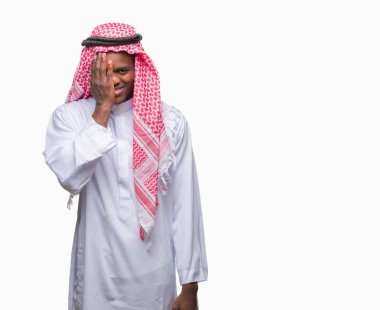 El yüz ve sürpriz duygu kendinden emin gülümseme ile tek gözüyle kapsayan izole arka plan üzerinde geleneksel keffiyeh giyen genç Arapça Afrika adam.