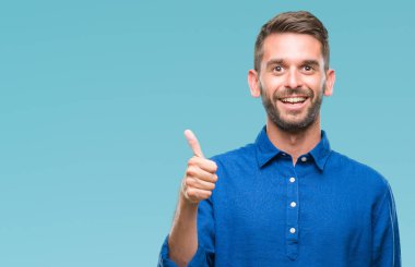 Yakışıklı delikanlı hareketi el ile mutlu yaşasın yapıyor izole arka plan üzerinde. Kameraya bakarak başarı gösteren ile ifade onaylama.