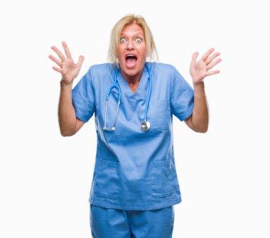 Orta yaş sarışın hemşire cerrah doktor kadın deli kutluyor arka plan izole ve başarı için kaldırdı kollarını açarak hayrete ve heyecanlı çığlık gözleri açık. Kazanan kavramı