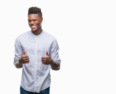 İzole arka plan başarı işareti el ile olumlu hareketi yaparken genç Afro-Amerikan adam başparmak gülümseyen ve mutlu. Neşeli bir ifadeyle, kazanan jest kameraya bakıyor.