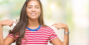 Yüzünde gülümseme ile kendinden emin görünüyorsun, kendini gururlu ve mutlu parmakları ile işaret izole arka plan genç güzel Arap kadın.