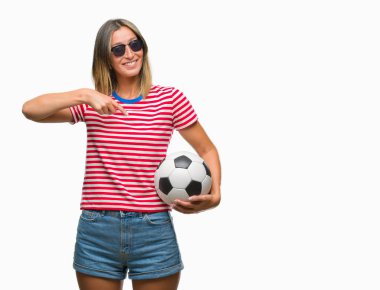 Sürpriz yüz işaret parmağı kendini izole arka plan üzerinde futbol futbol topu tutan genç güzel kadın