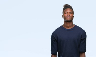 Afrikalı-Amerikalı genç yüzünde ciddi bir ifade ile izole arka plan üzerinde. Basit ve doğal kameraya bakıyor.