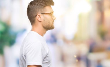 Genç yakışıklı adam gözlük izole arka tarafına, seyir üzerinde dinlenmek doğal yüz emin gülümseme ile pozuyla profili.