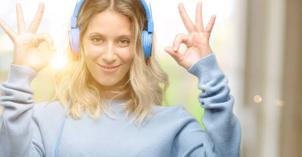 Joven Mujer Hermosa Escuchando Música Haciendo Gesto Signo Con Ambas — Foto de Stock