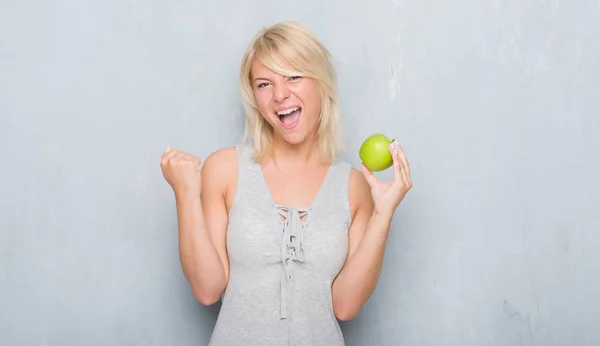 Mujer Caucásica Adulta Sobre Pared Gris Grunge Comiendo Manzana Verde —  Fotos de Stock