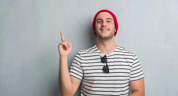 Joven Caucásico Hombre Sobre Gris Grunge Pared Usando Gorra Lana —  Fotos de Stock