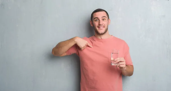 Junger Kaukasischer Mann Über Grauer Grunge Wand Trinkt Ein Glas — Stockfoto