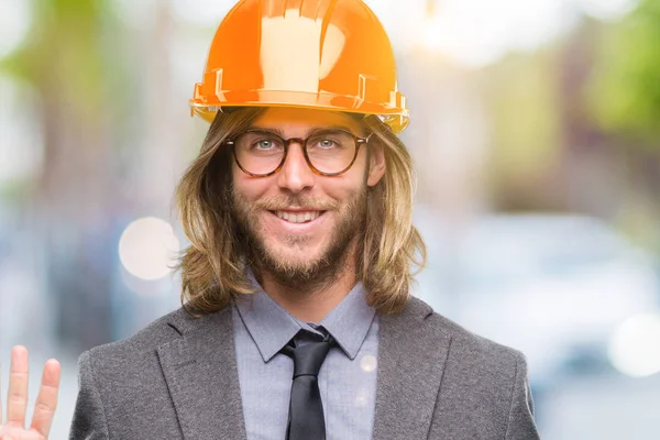 Junger Gutaussehender Architekt Mit Langen Haaren Schutzhelm Über Isoliertem Hintergrund — Stockfoto
