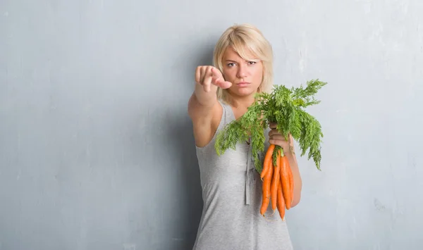 Mujer Adulta Caucásica Sobre Pared Grunge Gris Sosteniendo Zanahorias Frescas —  Fotos de Stock