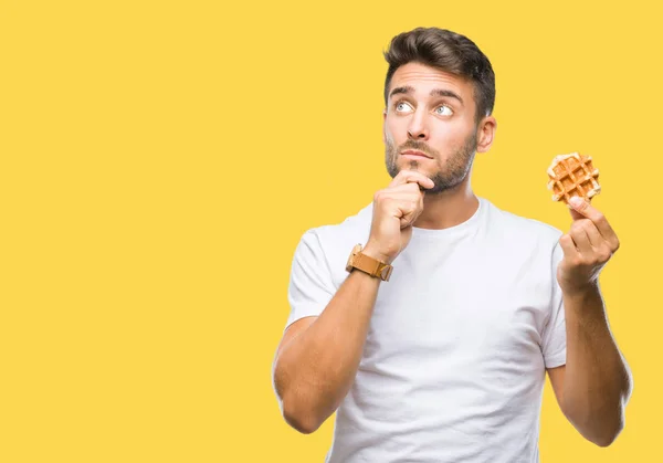 Young Handsome Man Eating Sweet Waffle Isolated Background Serious Face — Stock Photo, Image