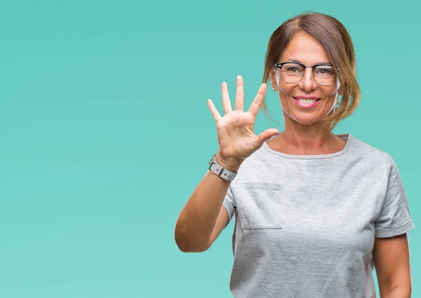 中年资深西班牙裔妇女戴眼镜在孤立的背景显示和指向手指五 而微笑着自信和快乐 — 图库照片