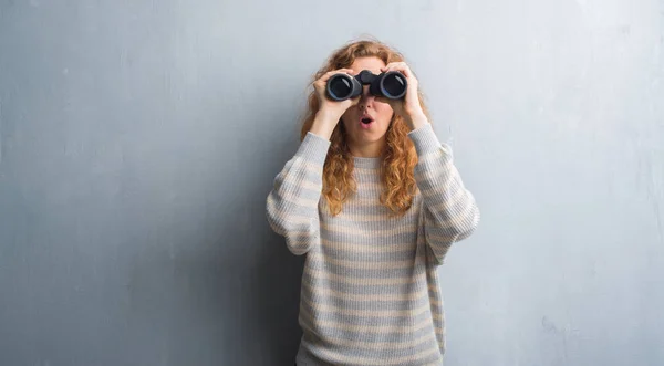 Young Redhead Woman Grey Grunge Wall Looking Binoculars Scared Shock — Stock Photo, Image