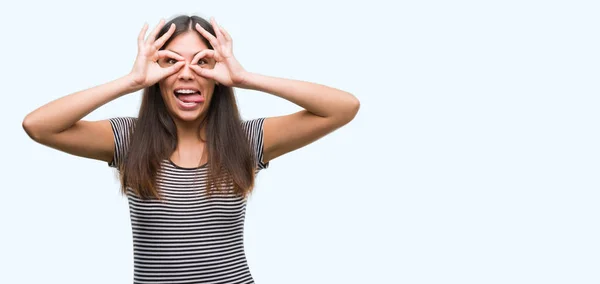 Young Beautiful Hispanic Woman Doing Gesture Binoculars Sticking Tongue Out — Stock Photo, Image