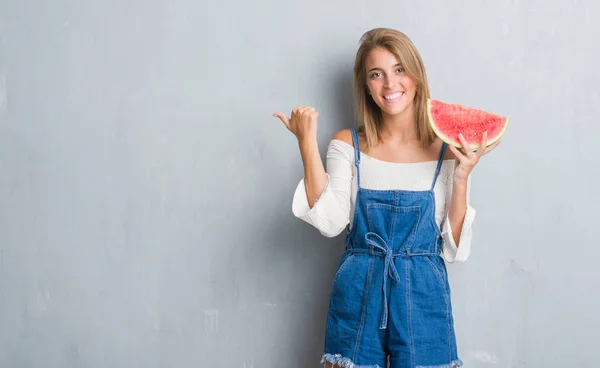 Hermosa Mujer Joven Sobre Pared Gris Grunge Comiendo Sandía Señalando — Foto de Stock