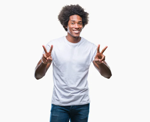 非裔美国男子在孤立的背景下微笑着看着相机显示手指做胜利标志 — 图库照片