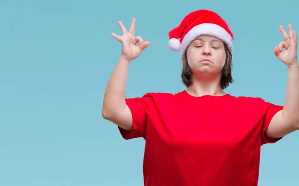 有唐综合症的年轻成年妇女戴着圣诞帽在与世隔绝的背景下放松和微笑闭着眼睛做冥想手势用手指 瑜伽理念 — 图库照片