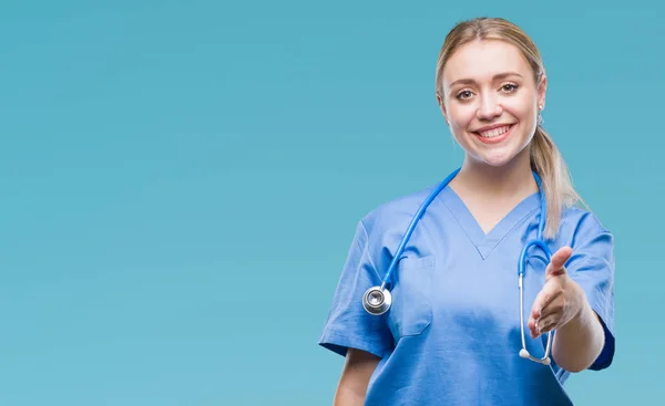 年轻金发女医生穿着医疗制服的蓝色背景 — 图库照片