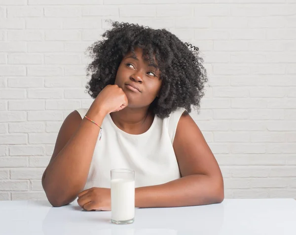 Mujer Afroamericana Joven Sentada Mesa Bebiendo Vaso Leche Cara Seria — Foto de Stock