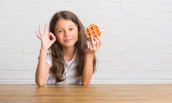Młode Dziecko Hiszpanin Siedzi Stole Jedzenie Wafel Robi Znak Palcami — Zdjęcie stockowe