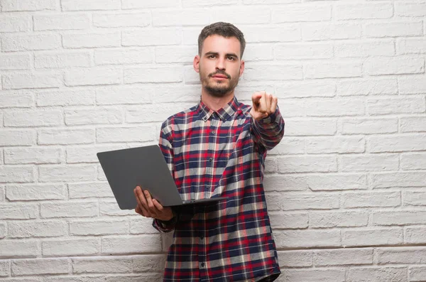 Молодий Дорослий Чоловік Над Цегляною Стіною Використовує Ноутбук Вказуючи Пальцем — стокове фото