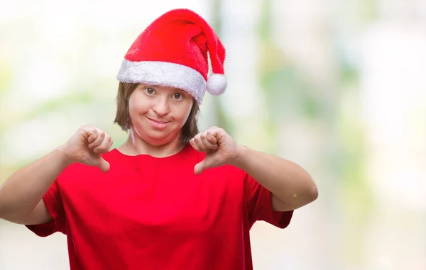 ダウン症の顔に笑顔と自信を持って 誇りと幸せな指で自分を指している孤立した背景にクリスマスの帽子をかぶっての若い成人女性 — ストック写真