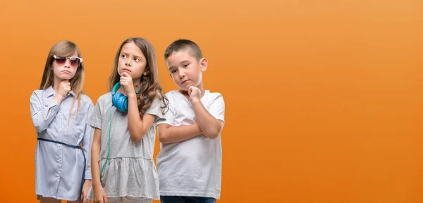 Gruppe Drenge Piger Børn Orange Baggrund Alvorligt Ansigt Tænker Spørgsmål - Stock-foto