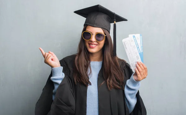 Joven Morena Sobre Pared Gris Grunge Con Uniforme Graduado Sosteniendo — Foto de Stock