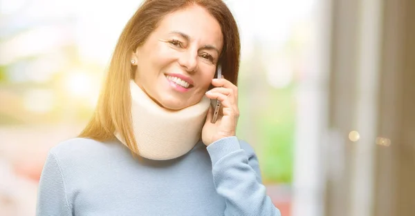戴着颈撑项圈的受伤妇女用智能手机交谈愉快 — 图库照片