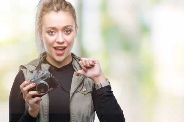 年轻的金发女人拍照使用老式相机在孤立的背景和惊讶的脸指向自己的手指 — 图库照片