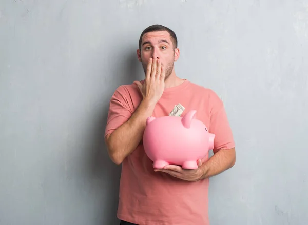 Young Caucasian Man Grey Grunge Wall Holding Piggy Bank Cover — Stock Photo, Image