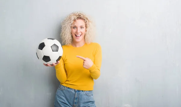 Joven Rubia Sobre Fondo Gris Grunge Sosteniendo Pelota Fútbol Muy —  Fotos de Stock