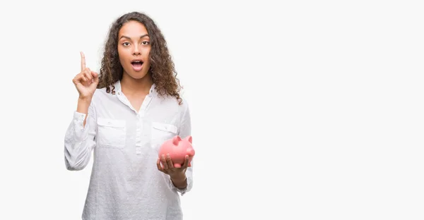 Young Hispanic Woman Holding Piggy Bank Surprised Idea Question Pointing — Stock Photo, Image