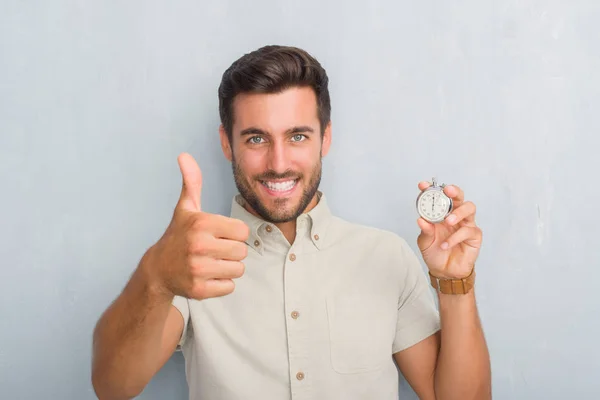 Schöner Junger Mann Über Grauer Grunge Wand Mit Stoppuhr Glücklich — Stockfoto