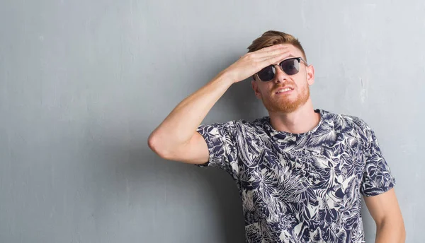 Junger Rothaariger Mann Über Grauer Grunge Wand Mit Sonnenbrille Hand — Stockfoto