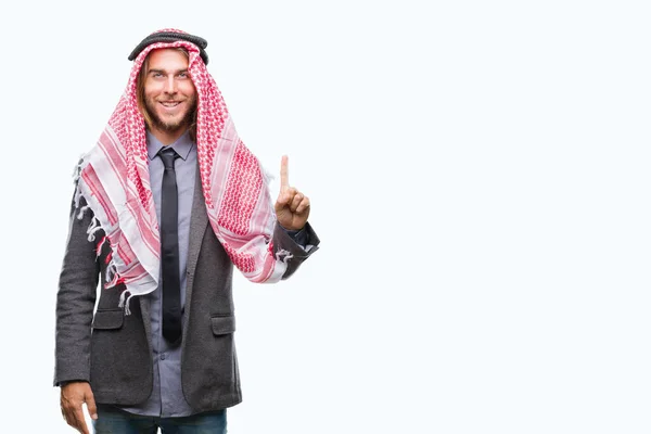年轻英俊的阿拉伯男子与长发穿着 Keffiyeh 在孤立的背景显示和指向的手指第一 而微笑着自信和快乐 — 图库照片