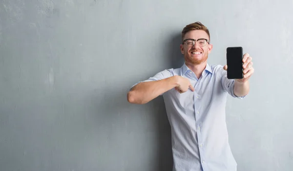 Young Redhead Man Grey Grunge Wall Showing Blank Screen Smartphone — Stock Photo, Image