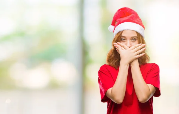 ミスのため手で口を覆っているショックを受けたクリスマスの帽子をかぶっている孤立した背景に若くてきれいな女性 秘密の概念 — ストック写真
