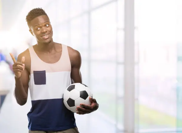 Joven Afroamericano Sosteniendo Pelota Fútbol Muy Feliz Apuntando Con Mano — Foto de Stock