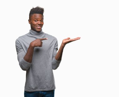 Genç Afro-Amerikan adam üzerinden hayran ve el ile sunulması ve parmak ile işaret ederken kameraya gülümseyen izole arka plan.