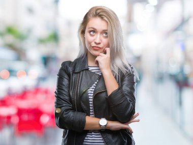 Genç Sarışın kadın moda ceket üzerinde arka plan çene düşünme hakkında soru, dalgın ifade üzerine el ile izole. Düşünceli yüzüyle gülümsüyor. Şüphe kavramı.