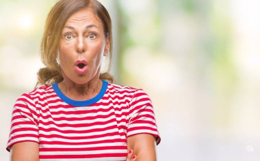 Orta yaş üst düzey İspanyol kadın izole arka plan korkuyor ve sürpriz ifade ile şok yüzünden korku ve yüz heyecanlı.