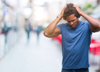 Afro Amerikalı adam çünkü umutsuz ve stresli baş ağrısı acı izole arka plan üzerinde ağrı ve migren. Ellerini kafasına.