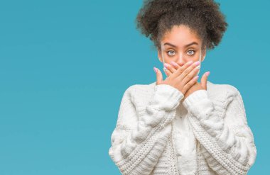 Üzerinde kış kazak giyen genç afro Amerikan kadın arka plan ağız hata için elleriyle kapsayan şok izole. Gizli kavramı.