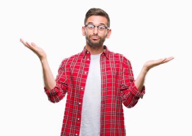 İzole arka plan clueless ve şaşkın bir ifadeyle kollar ve eller kaldırdı genç yakışıklı adam. Şüphe kavramı.