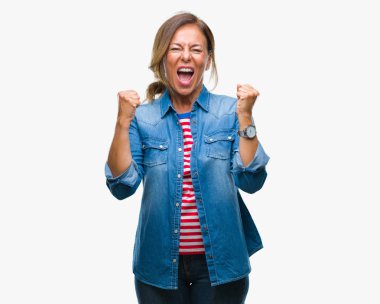 Gülümseyen ve başarı için çığlık orta yaş üst düzey İspanyol kadın izole arka plan çok mutlu ve heyecanlı kaldırdı, silah ile kazanan jest yapıyor. Kutlama kavramı.