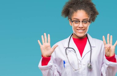 Genç afro Amerikalı doktor kadın gösterilen ve parmakları ile işaret izole arka plan üzerinde numara 9 kendinden emin ve mutlu gülümseyerek süre.