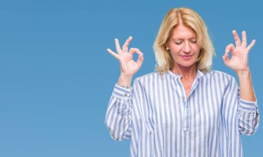 Orta yaş sarışın iş kadını izole arka plan üzerinde dinlenmek ve gülümseyen gözlerle parmak ile meditasyon jest yapıyor kapalı. Yoga kavramı.